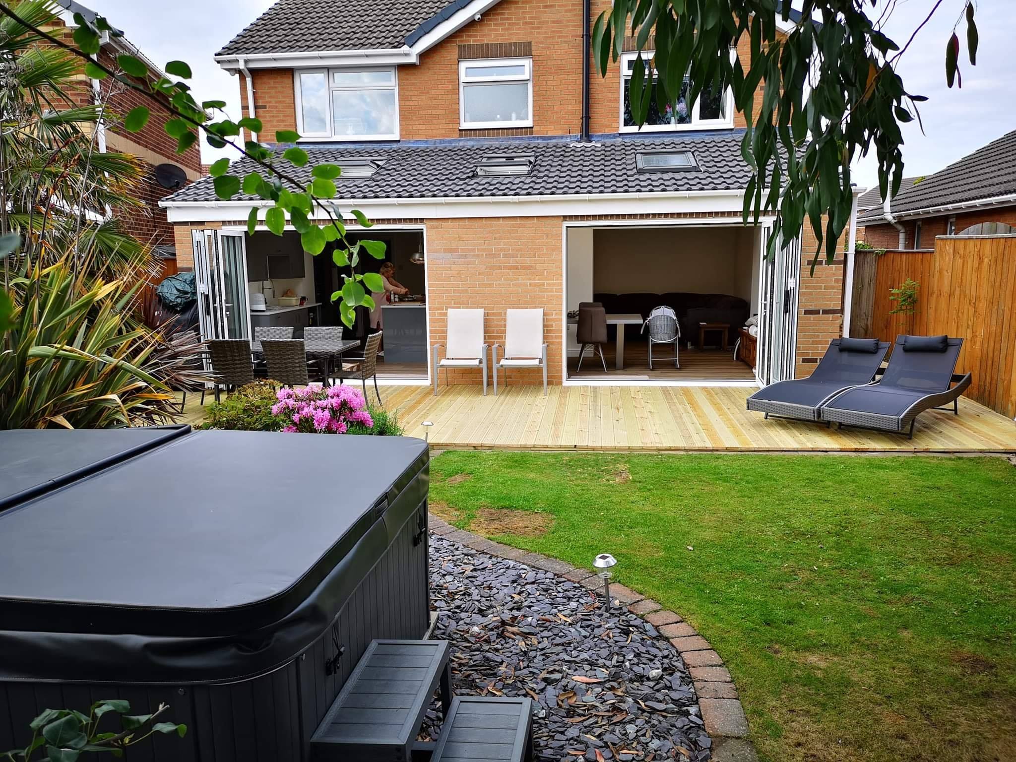 A finished single-storey rear extension with roof windows and two sets of bifold doors opening onto new decking